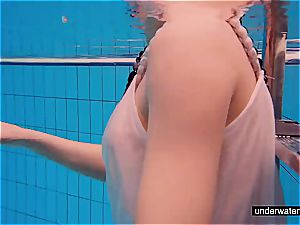 nubile female Avenna is swimming in the pool